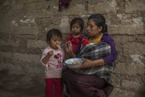 Twenty-six year old Guatemalan mother Maria is feeding crushed bananas to her daughter Mariela