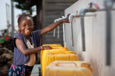 Une fille utilise une source d'eau potable
