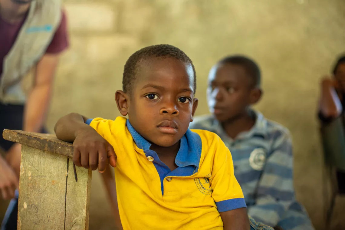 Un niño sentado durante una reunión con beneficiarios de un programa de agua limpia dirigido por UNICEF en la ciudad de Jérémie, en Haití.