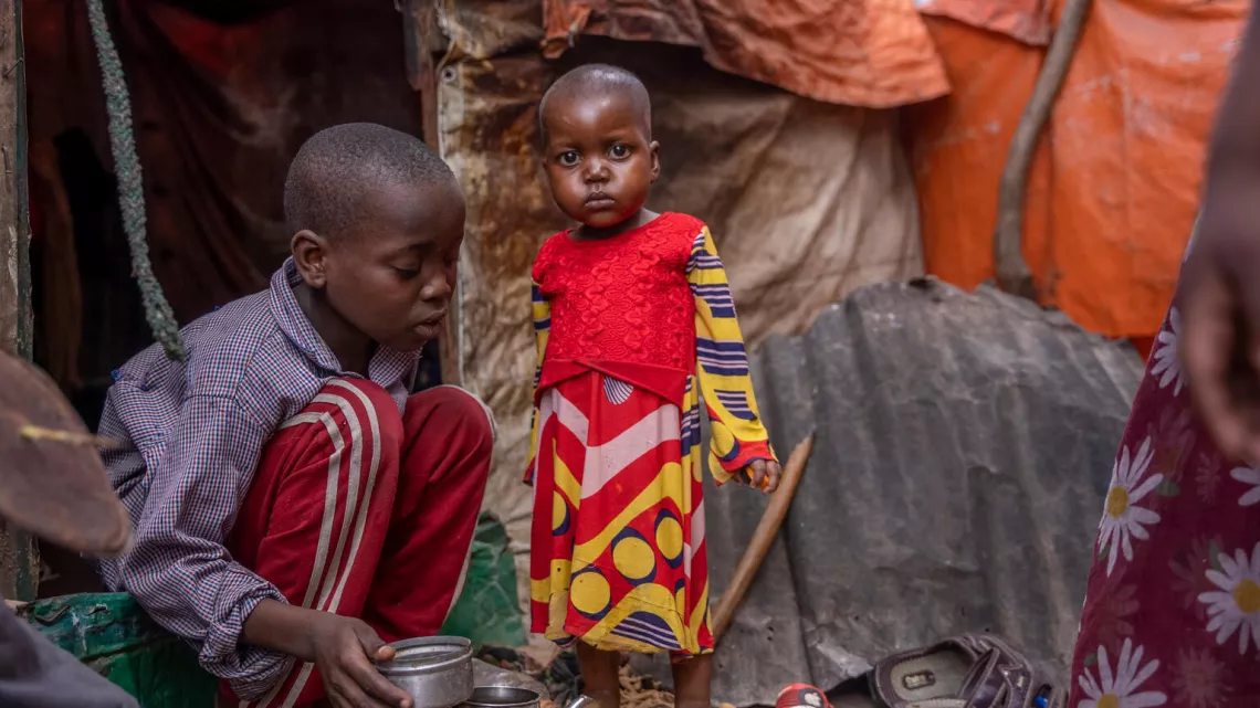 索马里摩加迪休郊区的一个境内流离失所者营地，一名女孩和她的兄弟在避难所外玩耍。