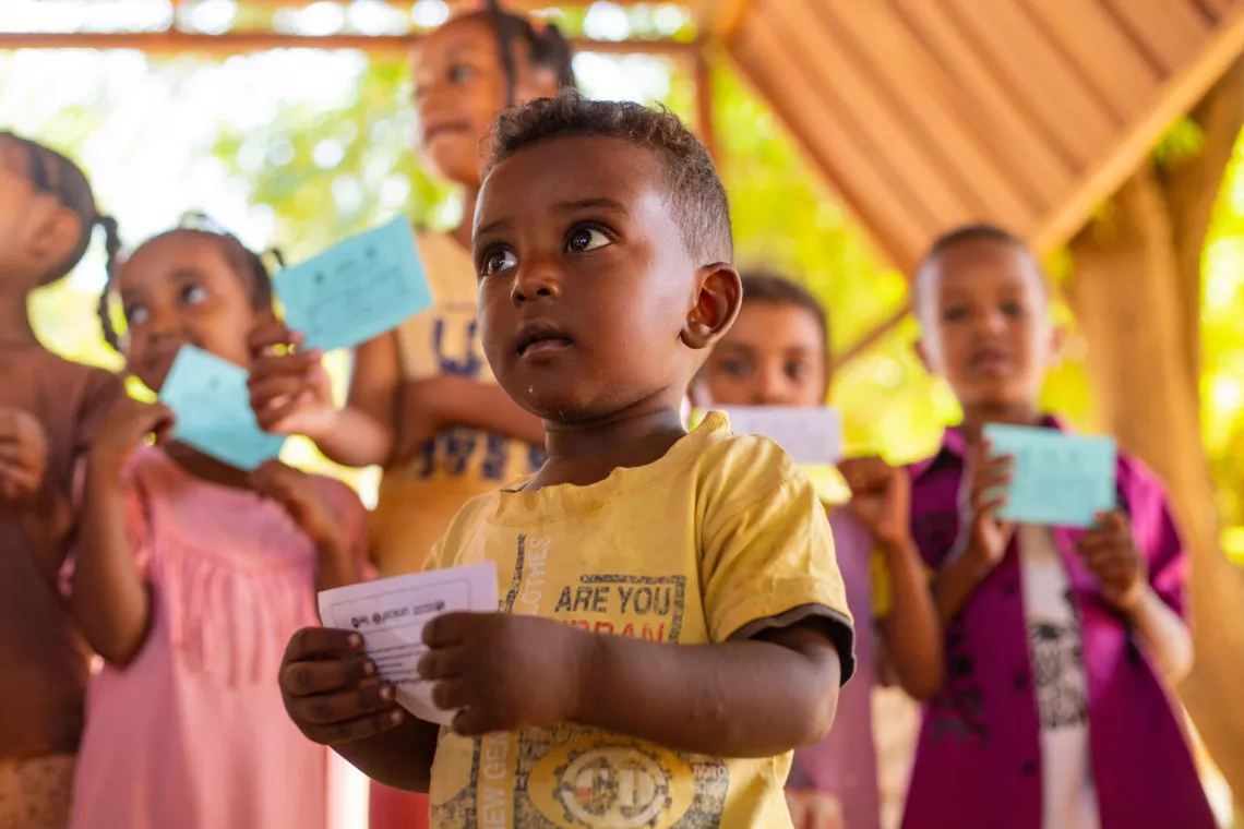 أطفال يعرضون بطاقات التطعيم بعد تلقي لقاح الكوليرا أثناء حملة التطعيم ضد الكوليرا في ولاية الجزيرة، السودان.