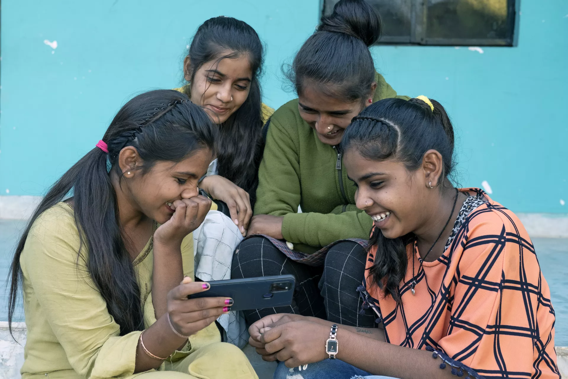 जेआर अनाथालय के छात्र स्मार्टफोन पर बॉलीवुड कॉमेडी देखते हैं।
