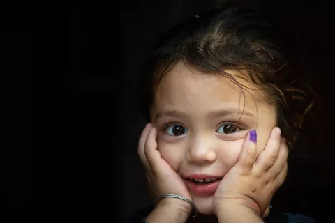 4-year-old Gul-e-Rukh poses for the UNICEF camera, showing her marked finger after receiving the polio vaccine, in Karachi, Pakistan.