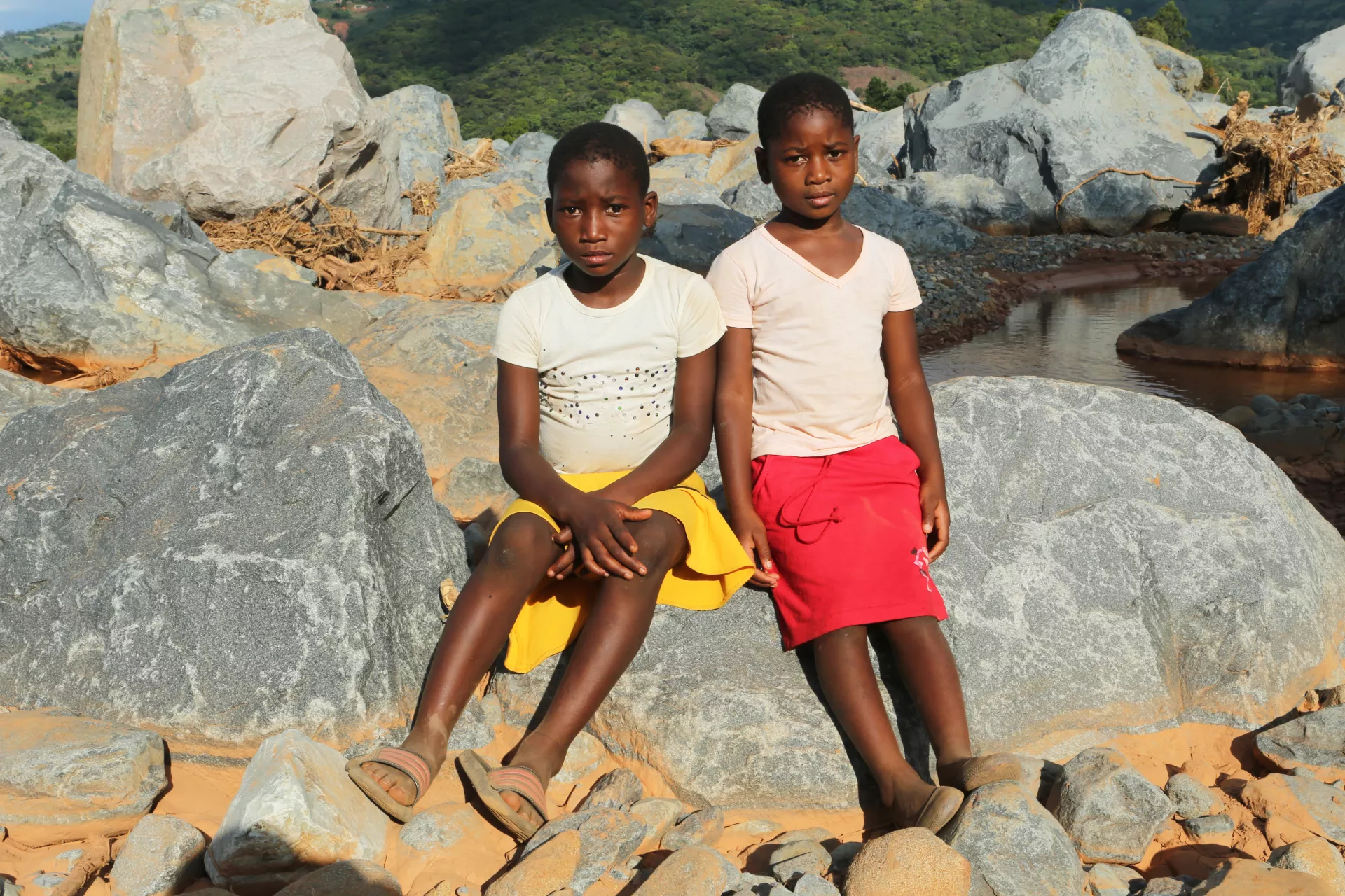 Zimbabwe. Two children sit near where their house was swept away by Cyclone Idai.
