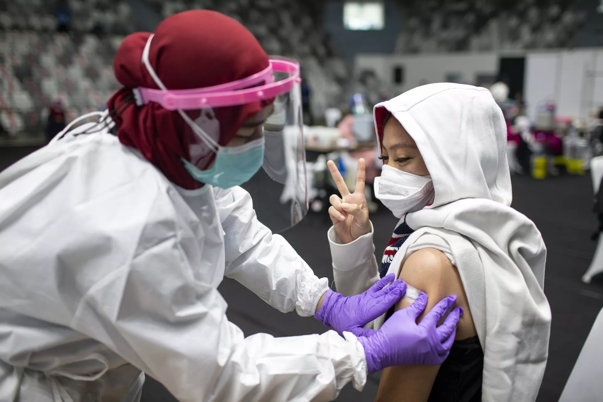Indonesia. A health worker receives the COVID-19 vaccine at a mass vaccination site.