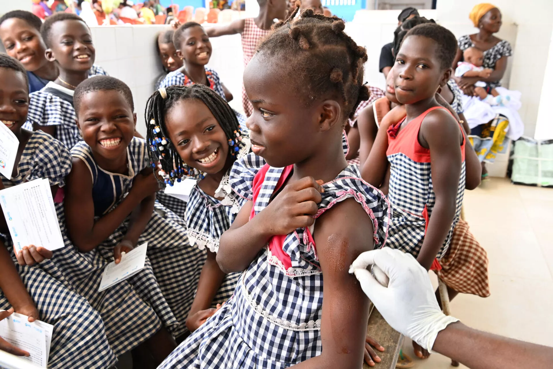Una niña recibe la vacuna contra el VPH junto a sus compañeras de escuela en un centro de salud de Côte d’Ivoire.
