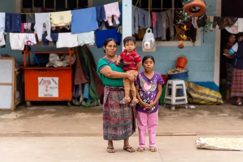 Guatemala. A family stand outside a shelter.