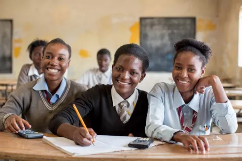 Tres niñas en una escuela de Zambia sonríen