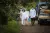 Deux agents de santé vêtus de blouses blanches marchent dans une rue. 