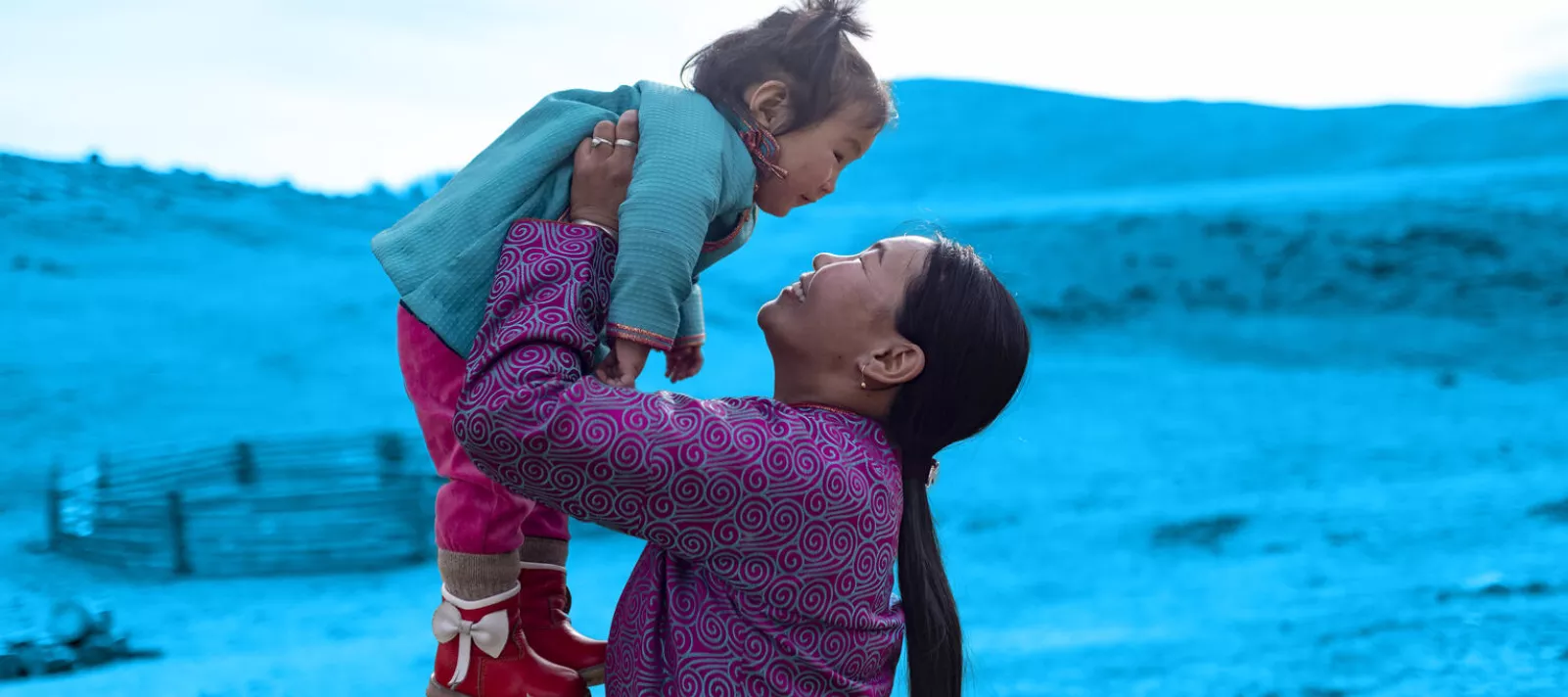 A mère portant son enfant près de leur yourte, Mongolie.