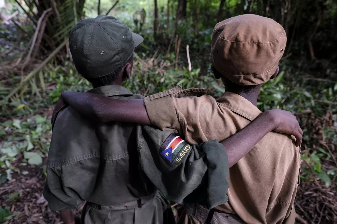 Le 17 avril 2018, à Yambio (Soudan du Sud), (de gauche à droite) Ganiko, 12 ans, et Jackson, 13 ans, [LES NOMS ONT ÉTÉ MODIFIÉS] assistent à une cérémonie marquant la démobilisation des enfants des rangs des groupes armés afin qu’ils entament un processus de réintégration. Jackson et Ganiko étaient très proches lorsqu’ils servaient ensemble au sein du groupe armé.