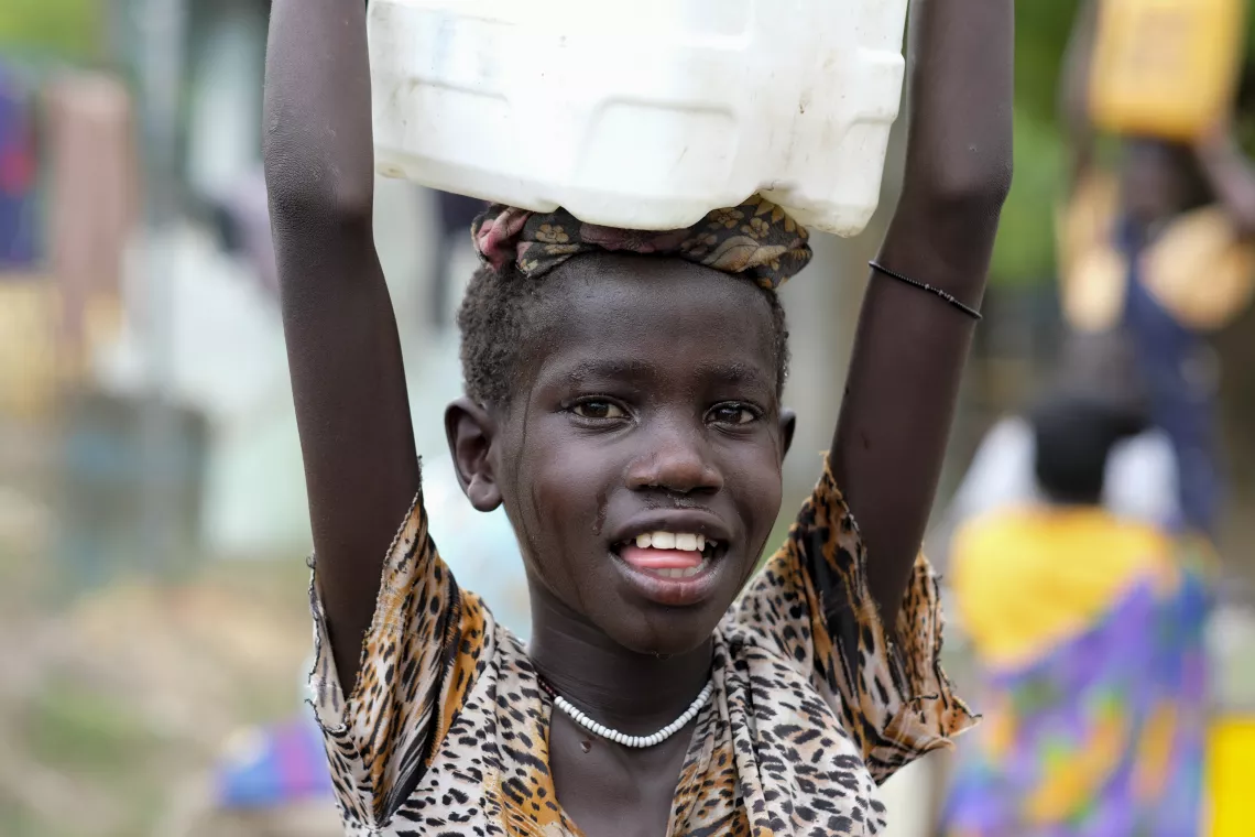 Sandy Chuol, 10, heads home with the jerrycan of clean water