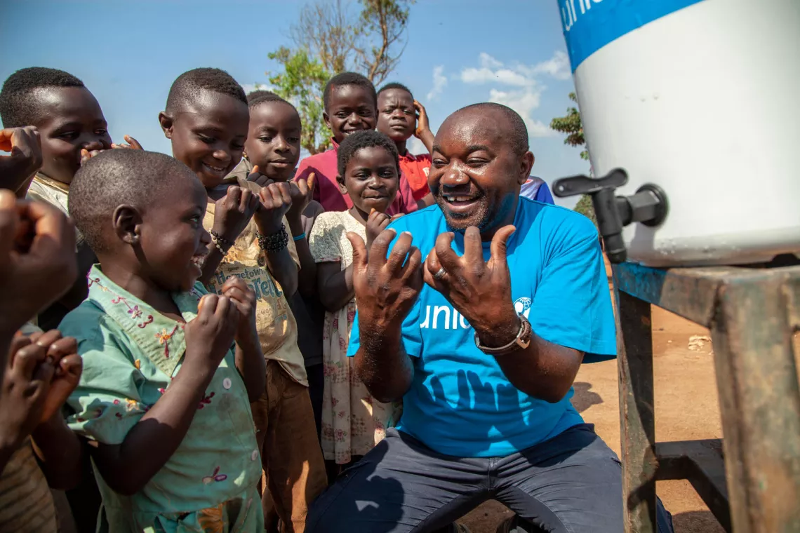 A UNICEF worker encourages children to wash their hands in the Democratic Republic of Congo.