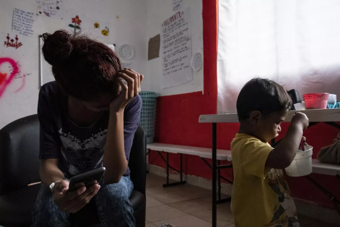 Una madre mira a su hijo jugar en un refugio en México