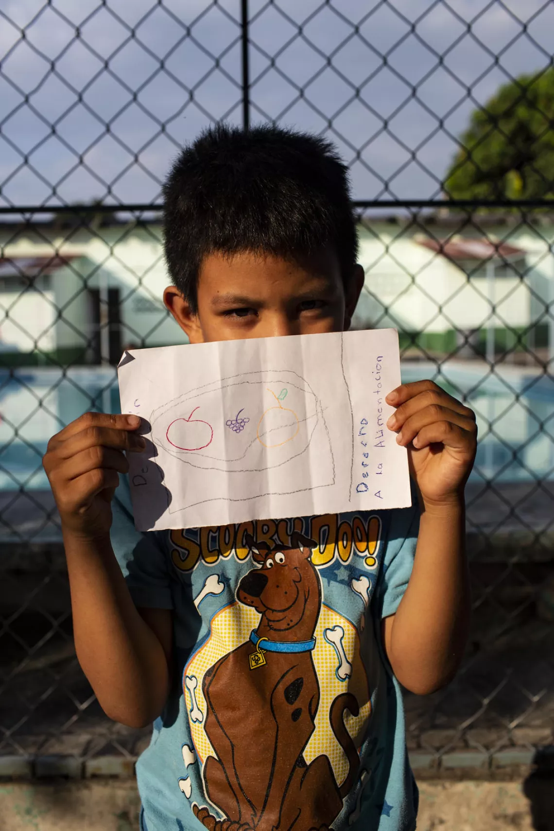 Un niño migrante muestra su dibujo, México