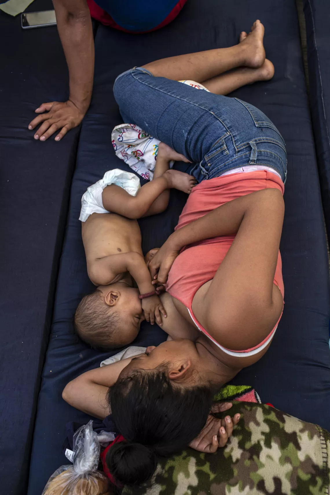 Una mujer da pecho a su hijo en un refugio temporal en México