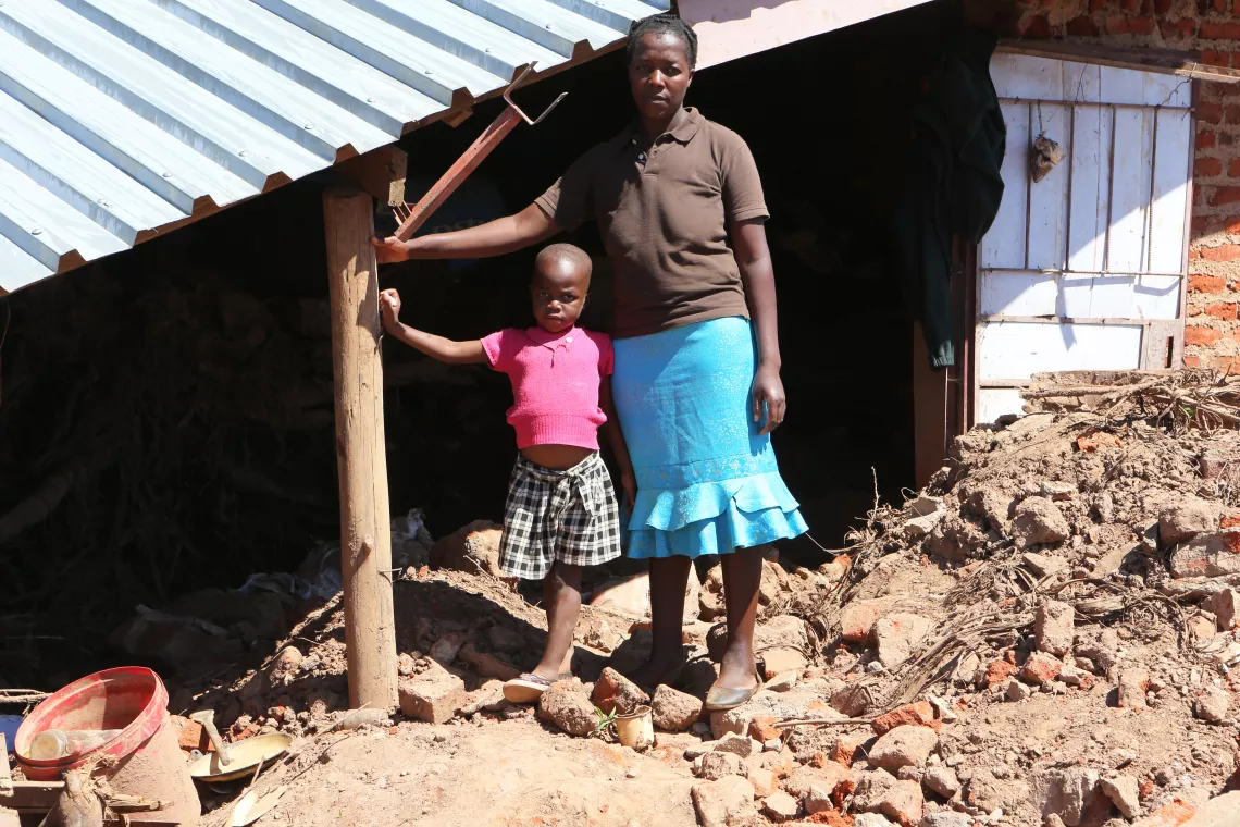 Zimbabwe. A girl and her mother stand in front of the remains of their home, which was destroyed by Cyclone Idai.