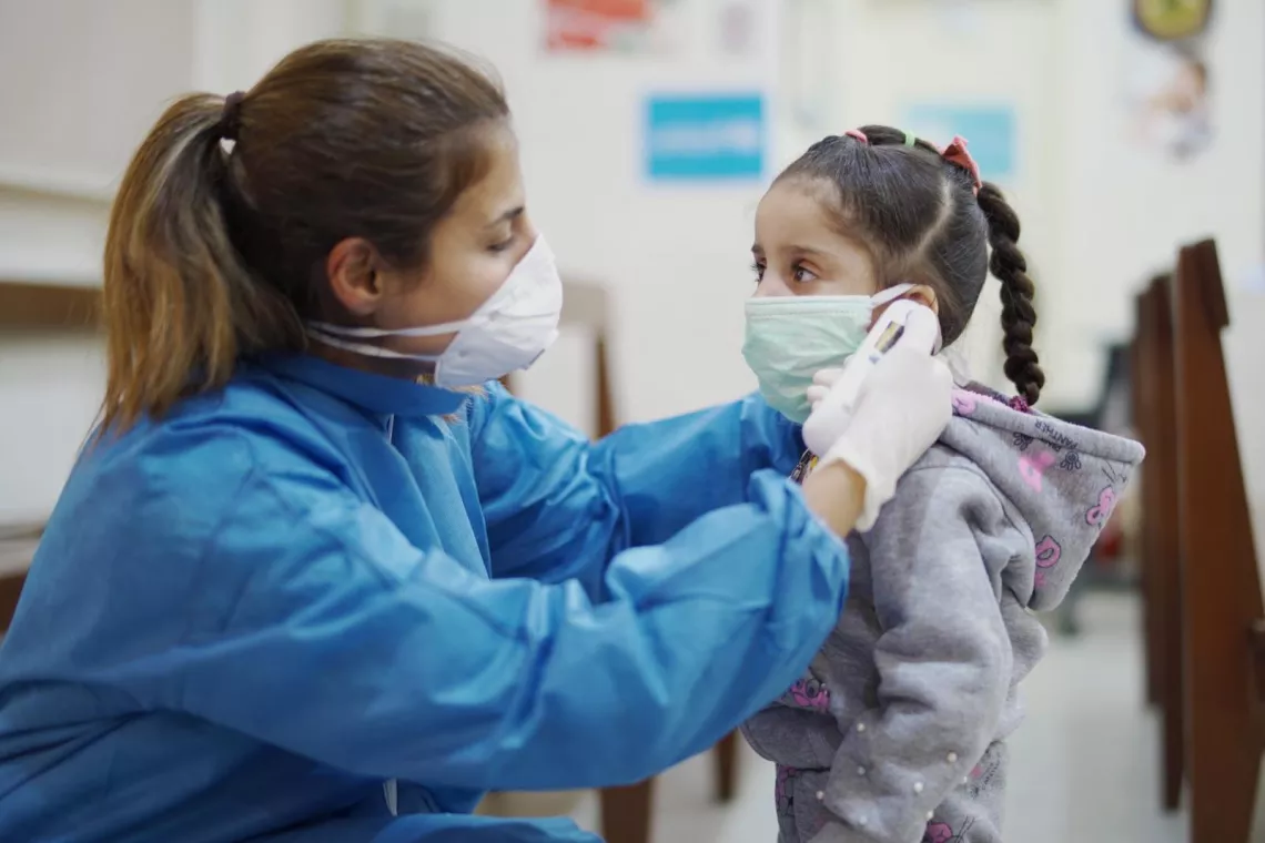 Une infirmière prend la température d'une enfant dans un centre de soins de santé de primaires à Beyrouth, au Liban.