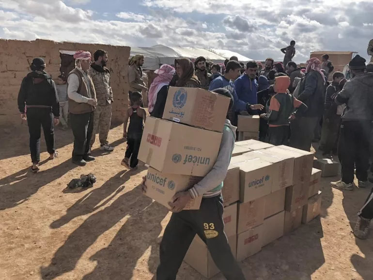 توزع الإمدادات الإنسانية التابعة لليونيسف على الأطفال والعائلات في مخيم الرُكبان في جنوب شرق سوريا بالقرب من الحدود الأردنية، حيث يعيش ما يقرب من 50,000 شخص، معظمهم من النساء والأطفال