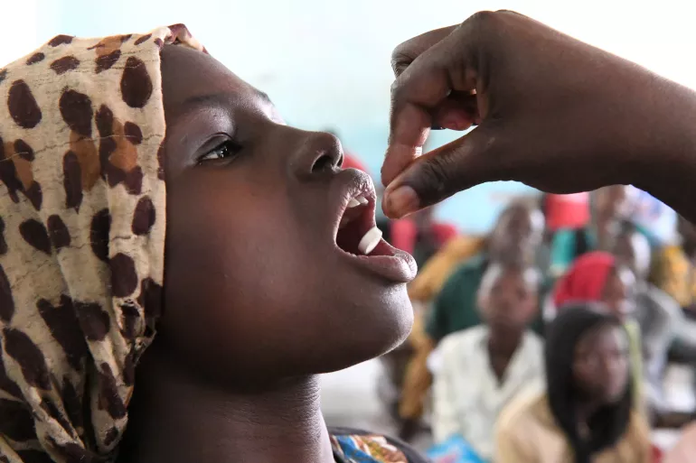 Une fille reçoit une dose de vaccin par voie orale 