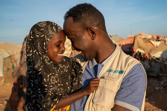 2018年12月10日，在索马里，联合国儿童基金会儿童保护工作人员与一名居住在加罗威境内流离失所者营地的女孩交谈。